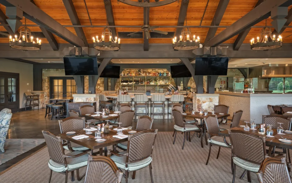 Dining room and bar area at Capital City Club Brookhaven featuring multiple wall-mounted displays installed by Macrotek Services