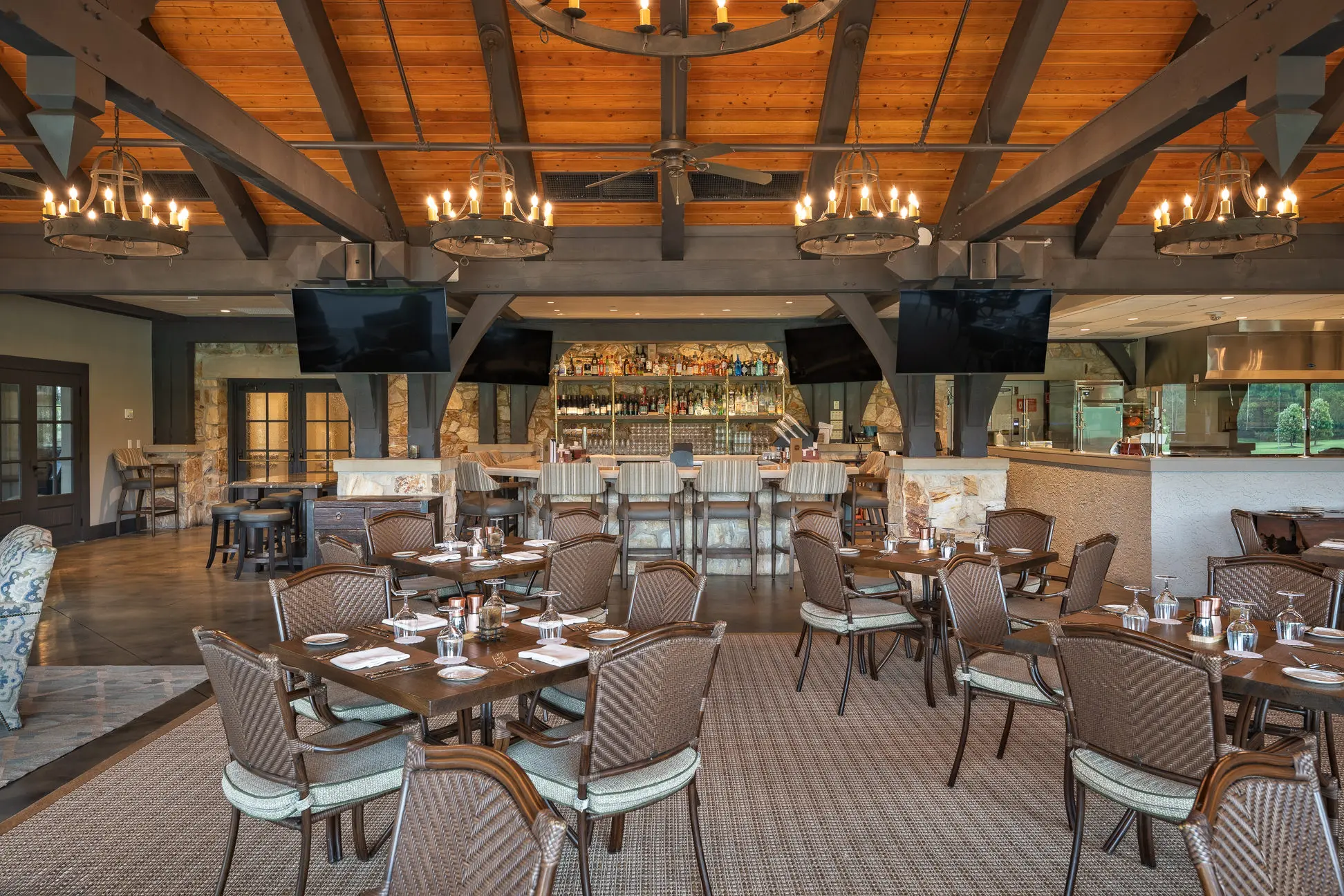 Dining room and bar area at Capital City Club Brookhaven featuring multiple wall-mounted displays installed by Macrotek Services