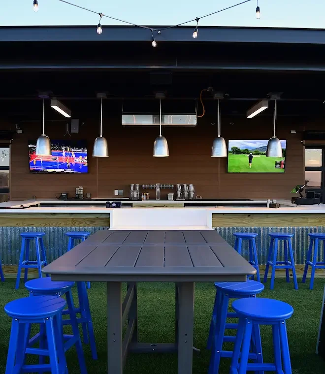 Rooftop bar at an entertainment venue with patio seating, lighting, and city views