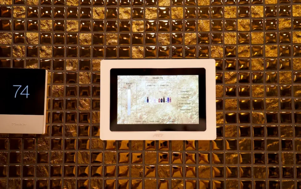Smart control panel installed on a gold-tiled studio wall, managing lighting, sound, and visual content systems