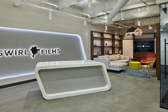 Modern reception area and client lounge at Swirl Films headquarters featuring branded digital signage and integrated AV system