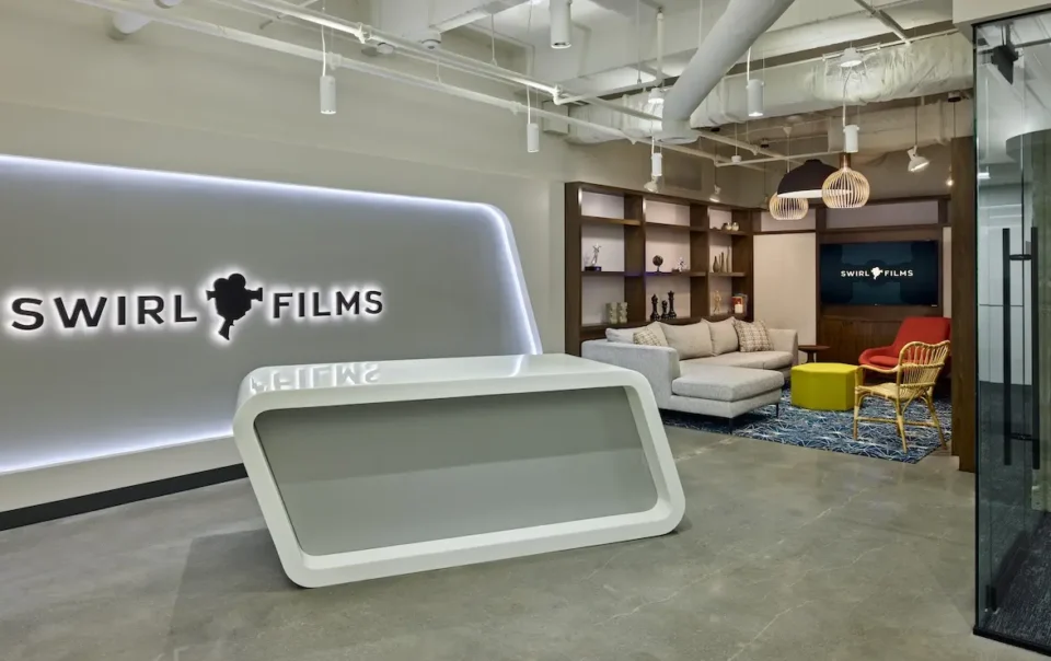 Modern reception area and client lounge at Swirl Films headquarters featuring branded digital signage and integrated AV system
