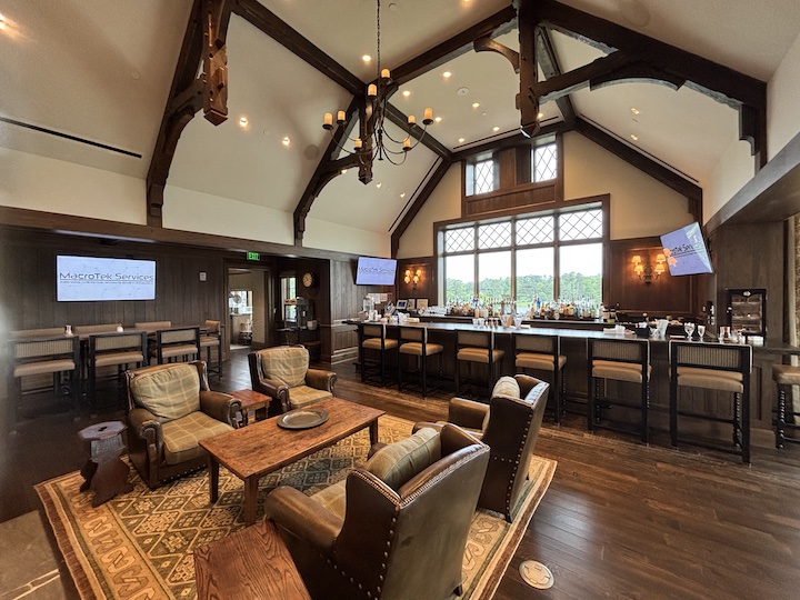 Private club dining room lounge with mounted digital AV displays and vaulted ceiling
