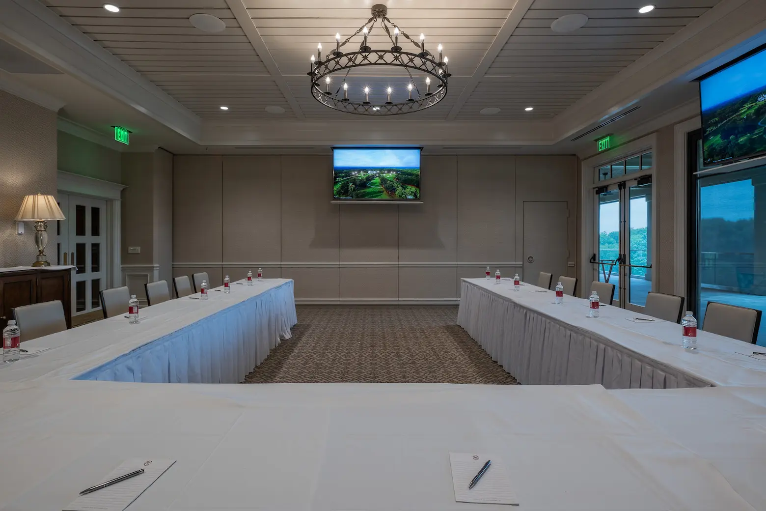 Country club conference room with wall-mounted AV display and U-shaped table layout for meetings