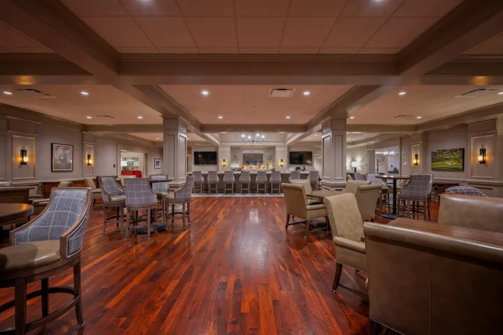 Private club lounge featuring mounted AV displays and high-end audio system near bar area