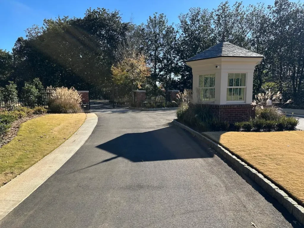 Gated community entrance with modern guard house and surveillance
