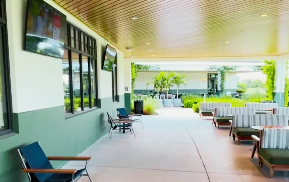 Covered member lounge featuring mounted smart TVs and directional audio